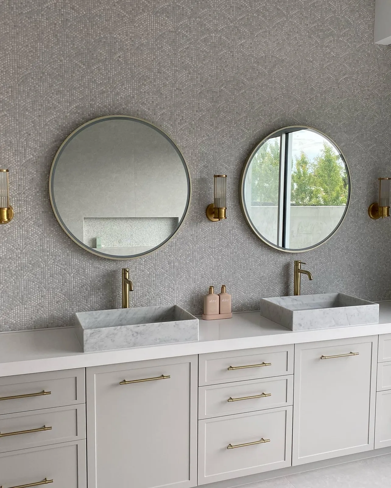 Ensuite twin vanity with round mirrors, textured feature wall and stone vessel basins