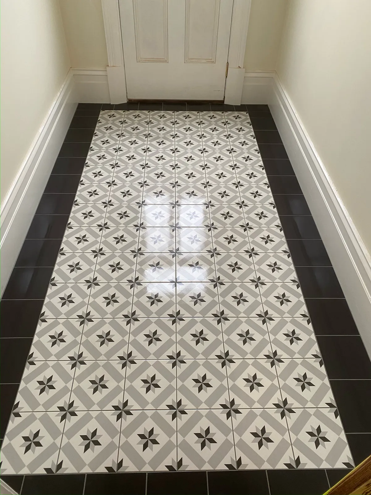 Geometric grey and black patterned tile floor in a hallway entryway