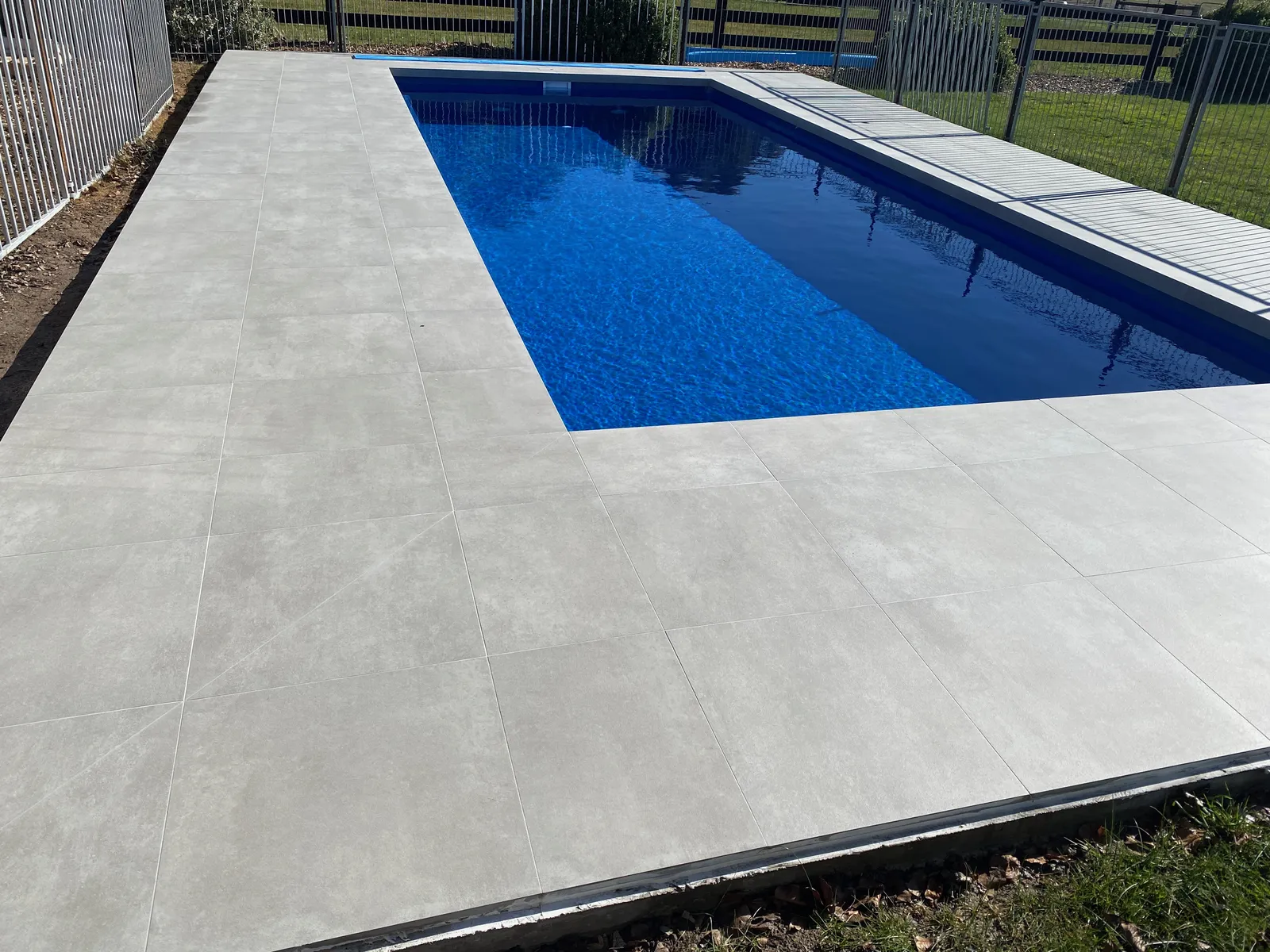 Backyard pool with large-format grey porcelain paving