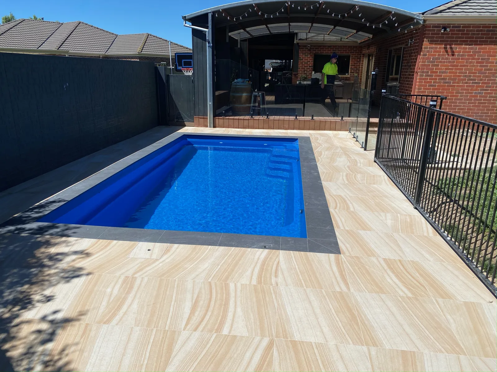 Pool surround paved with sandstone-look porcelain pavers