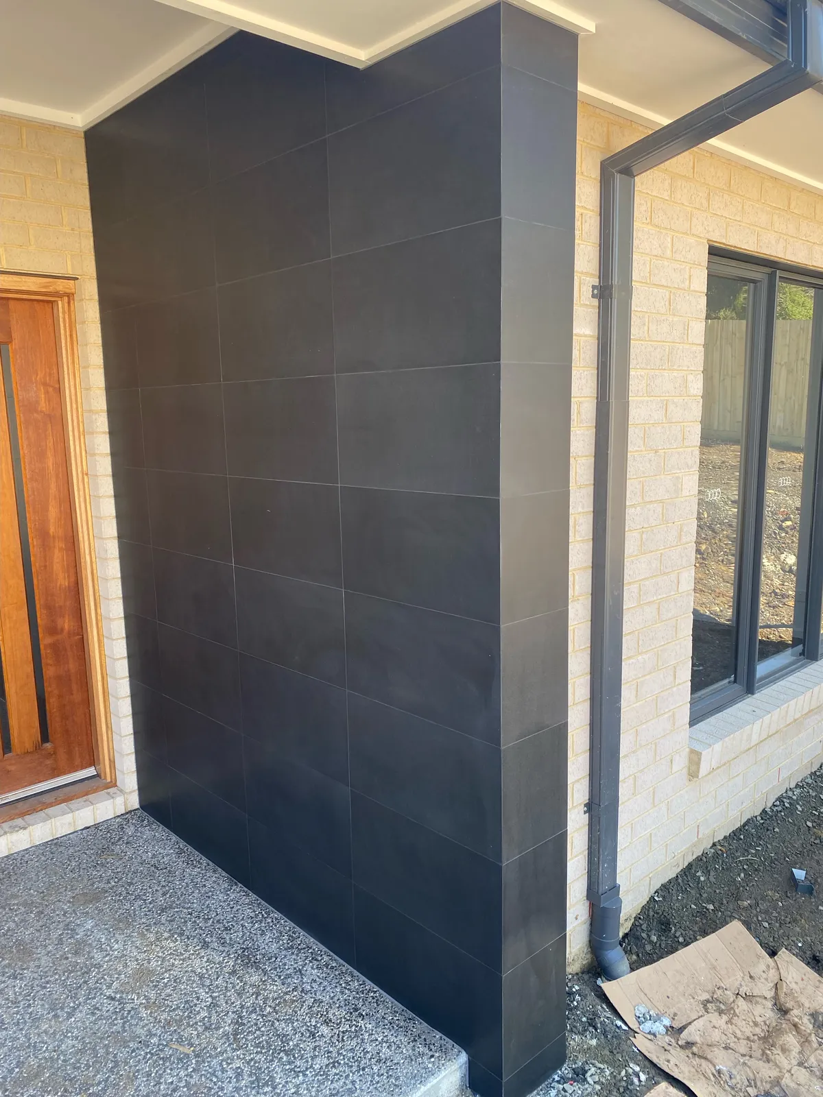 Exterior entrance with black large-format porcelain feature wall tiling