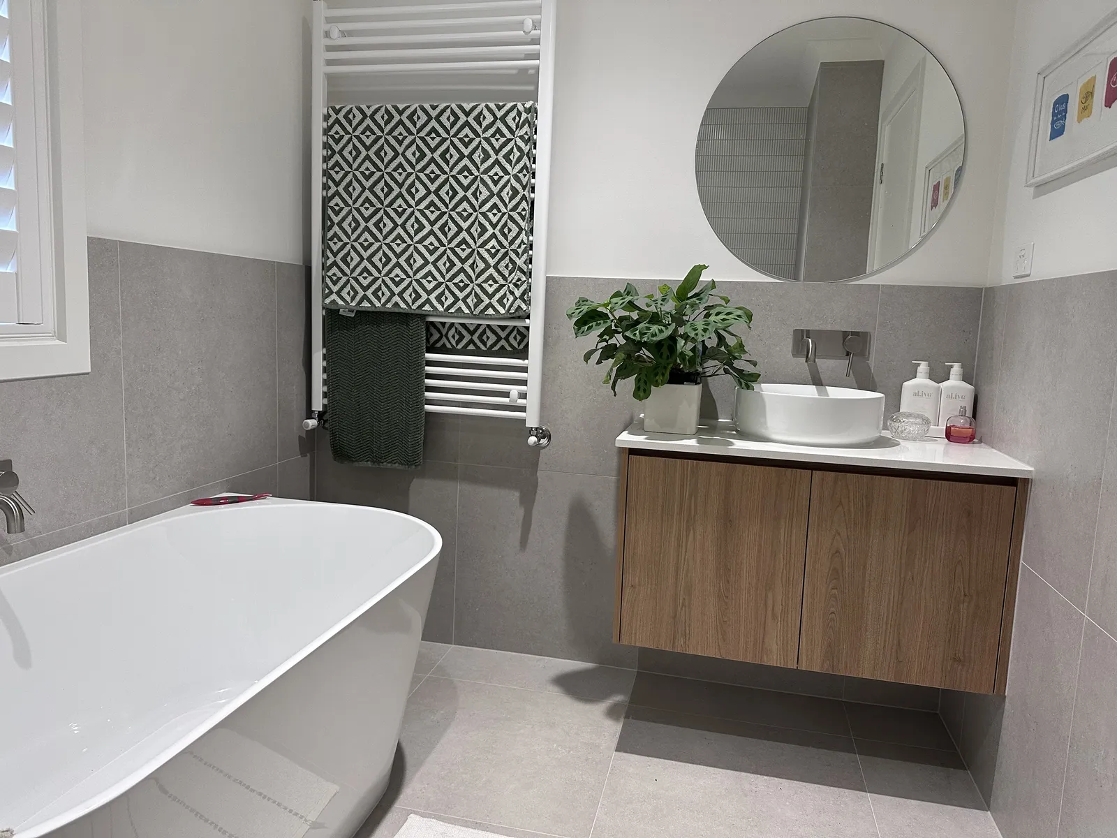 Bathroom with freestanding bath, timber vanity, vessel basin and patterned feature