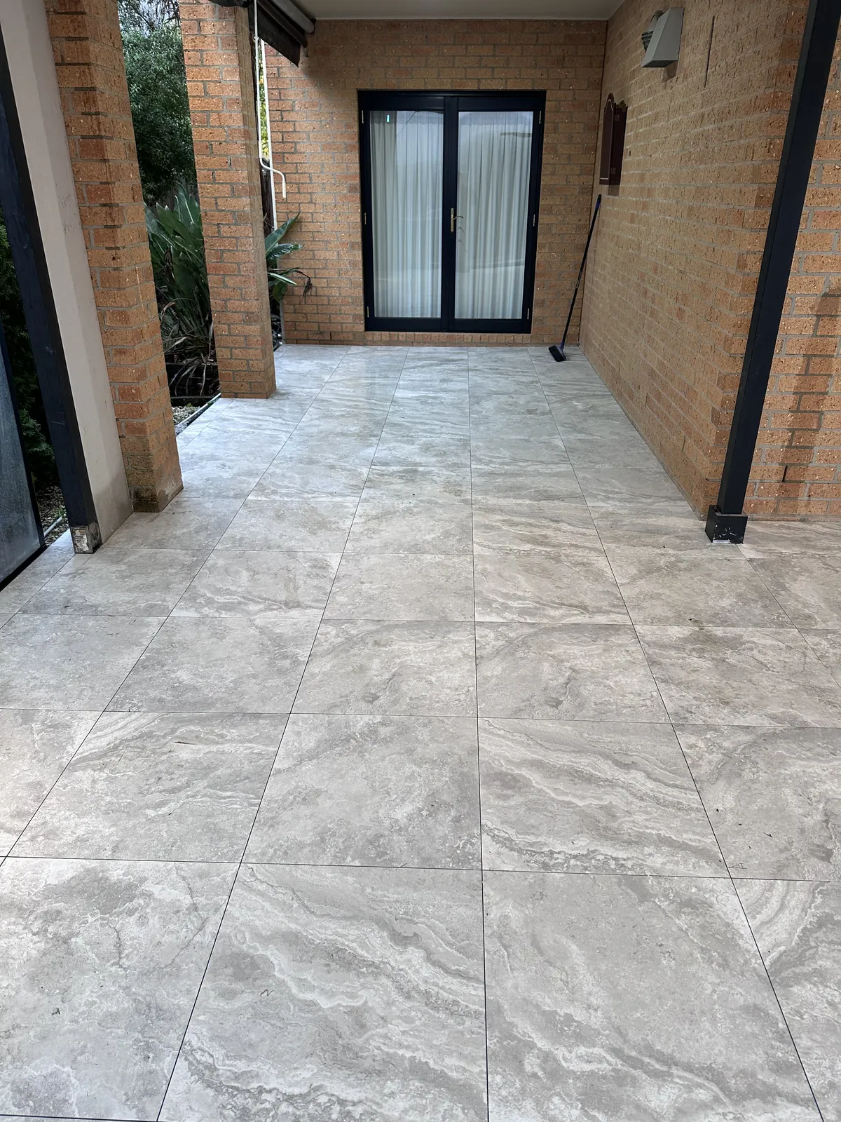 Covered alfresco courtyard paved with travertine-look porcelain tiles